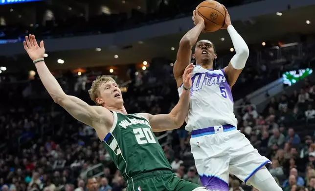 Utah Jazz's Cody Williams (5) shoots against Milwaukee Bucks' AJ Green during the first half of an NBA basketball game Saturday, March 7, 2026, in Milwaukee. (AP Photo/Aaron Gash)