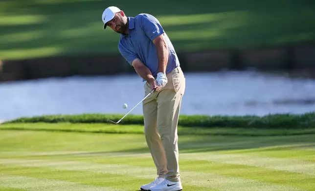Scottie Scheffler chips onto the 11th green during the second round of The Players Championship golf tournament Friday, March 13, 2026, in Ponte Vedra Beach, Fla. (AP Photo/Gerald Herbert)