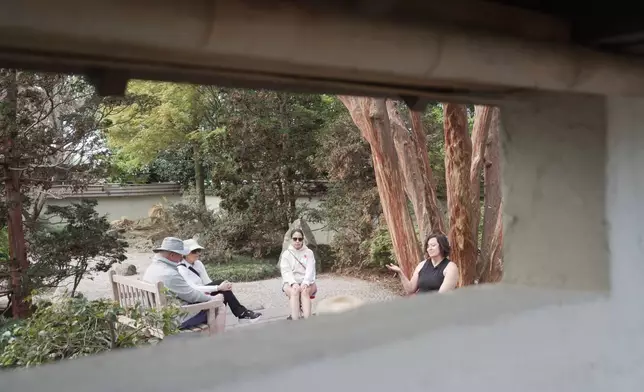 Forest therapy guide Shawn Ramsey, far right, leads a "forest bathing" session in a walled Japanese garden at the J.C. Raulston Arboretum in Raleigh, N.C., on Sunday, March 22, 2026. (AP Photo/Allen G. Breed)