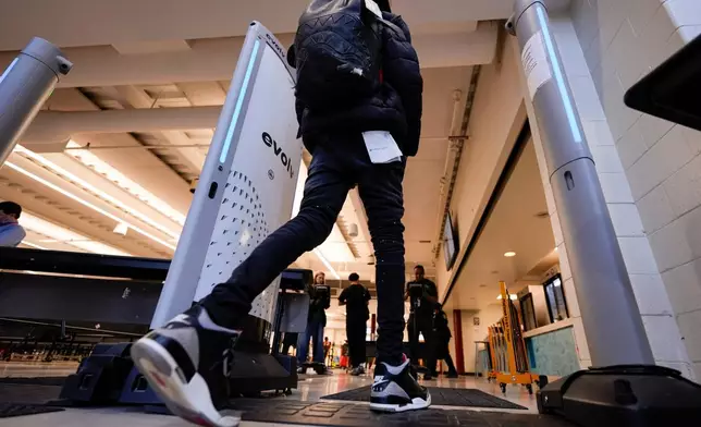 A student walks through security at Midtown High School, Friday, March 6, 2026, in Atlanta. (AP Photo/Mike Stewart)