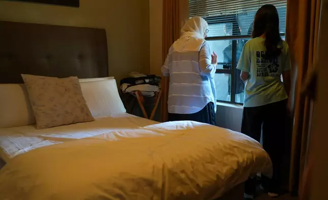 Palestinians who traveled to South Africa via a charter flight organized by an Israeli group whose founder supported U.S. President Donald Trump's proposal to resettle Palestinians from Gaza stand in their temporary flat in Johannesburg, South Africa, Wednesday, Feb. 4, 2026. (AP Photo/Jerome Delay)