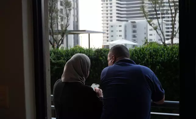 Palestinians who traveled to South Africa via a charter flight organized by an Israeli group whose founder supported U.S. President Donald Trump's proposal to resettle Palestinians from Gaza stand in their temporary flat in Johannesburg, South Africa, Wednesday, Feb. 4, 2026. (AP Photo/Jerome Delay)