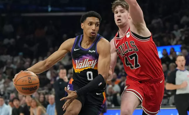 Phoenix Suns forward Ryan Dunn drives on Chicago Bulls center Lachlan Olbrich (47) during the first half of an NBA basketball game, Thursday, March 5, 2026, in Phoenix. (AP Photo/Rick Scuteri)