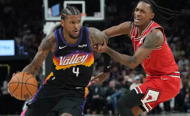 Phoenix Suns guard Jalen Green (4) drives around the Chicago Bulls guard Rob Dillingham during the first half of an NBA basketball game, Thursday, March 5, 2026, in Phoenix. (AP Photo/Rick Scuteri)