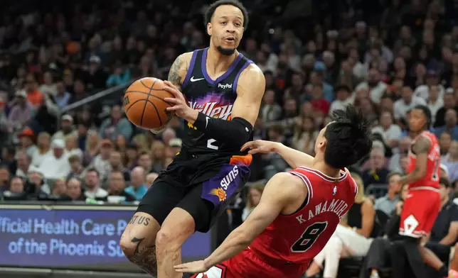 Phoenix Suns guard Amir Coffey gets fouled by Chicago Bulls guard Yuki Kawamura (8) during the first half of an NBA basketball game, Thursday, March 5, 2026, in Phoenix. (AP Photo/Rick Scuteri)
