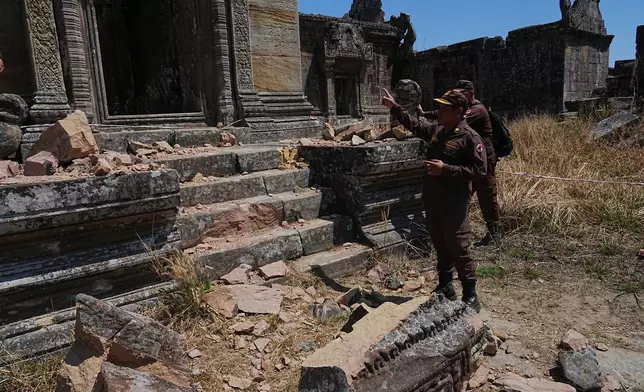 Cambodian Mine Action Center, CMAC, members stand near a temple damaged during border clashes with Thailand, at Preah Vihear province, Cambodia, Saturday, March 14, 2026. (AP Photo/Heng Sinith)