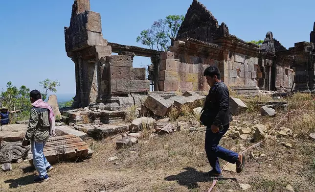 Cambodian police officers walk past a temple damaged during border clashes with Thailand, at Preah Vihear province, Cambodia, Saturday, March 14, 2026, (AP Photo/Heng Sinith)