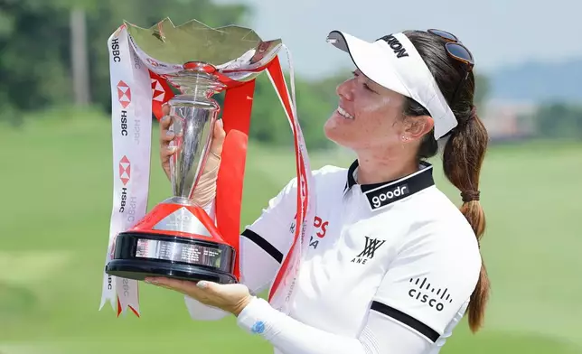 Hannah Green of Australia poses with the tournament trophy after winning the HSBC Women's World Championship at Sentosa Golf Club in Singapore, Sunday, March 1, 2026. (AP Photo/Suhaimi Abdullah)
