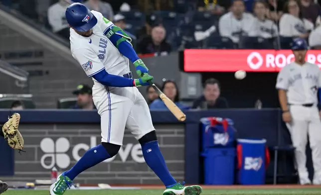 Toronto Blue Jays designated hitter George Springer hits a solo home run against the Colorado Rockies in third-inning baseball game action in Toronto, Monday, March 30, 2026. (Jon Blacker/The Canadian Press via AP)