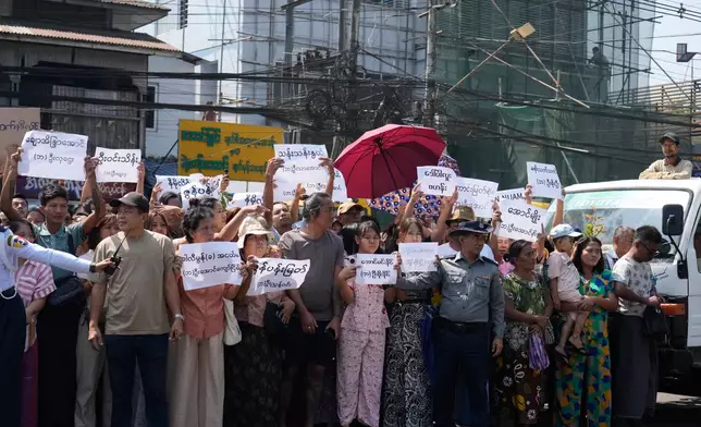Family members and colleagues holding name cards wait to welcome the released prisoners from Insein Prison Monday, March 2, 2026, in Yangon, Myanmar. (AP Photo/Thein Zaw)