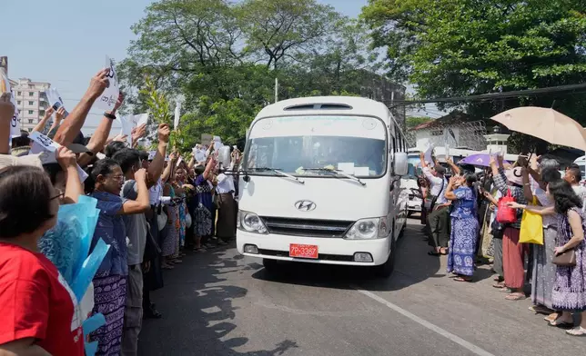 Released prisoners, in a bus, are welcomed by family members and colleagues after they left Insein Prison Monday, March 2, 2026, in Yangon, Myanmar. (AP Photo/Thein Zaw)