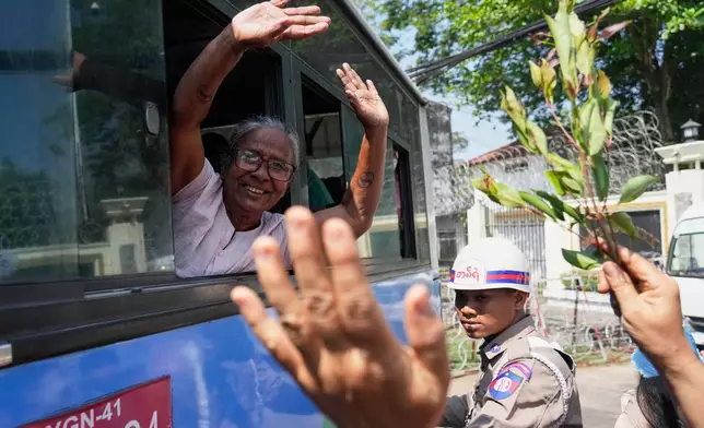 Released prisoners, in a bus, is welcomed by family members and colleagues after they left Insein Prison Monday, March 2, 2026, in Yangon, Myanmar. (AP Photo/Thein Zaw)