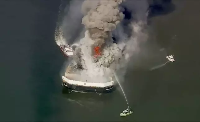 Firefighters battle a massive blaze that erupted on a barge on the Delaware River on Tuesday, March 10, 2026 in New Castle, Del. (WPVI via AP)