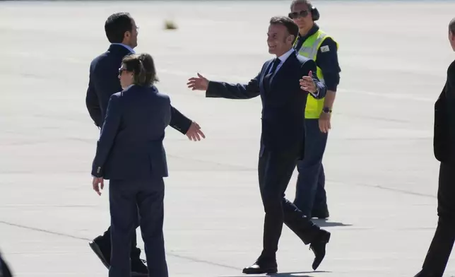 French President Emmanuel Macron, right, is welcomed by Cyprus President Nikos Christodoulides, left, at Andreas Papandreou Air Base in Paphos, Cyprus, on Monday, March 9, 2026. (AP Photo/Petros Karadjias)