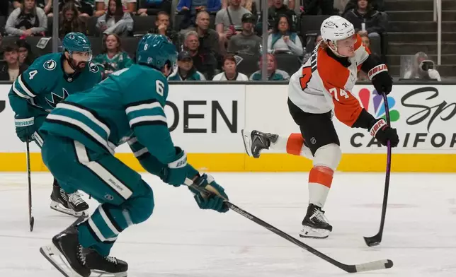 Philadelphia Flyers right wing Owen Tippett, right, scores a goal next to San Jose Sharks defenseman Nick Leddy (4) and defenseman Sam Dickinson (6) during the second period of an NHL hockey game in San Jose, Calif., Saturday, March 21, 2026. (AP Photo/Jeff Chiu)