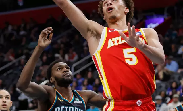 Atlanta Hawks guard Dyson Daniels (5) goes in for a layup past Detroit Pistons forward Paul Reed (7) during the first half of an NBA basketball game Wednesday, March 25, 2026, in Detroit. (AP Photo/Duane Burleson)