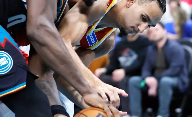 Detroit Pistons center Jalen Duren, left, and Atlanta Hawks forward Zaccharie Risacher scramble for the ball during the first half of an NBA basketball game Wednesday, March 25, 2026, in Detroit. (AP Photo/Duane Burleson)