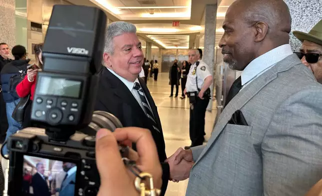 Kenneth Windley, right, shakes hands with Brooklyn District Attorney Eric Gonzalez at the courthouse in the Brooklyn borough of New York, Monday, March 16, 2026. (AP Photo/Jennifer Peltz)