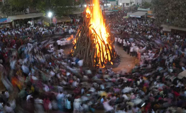 Indians perform rituals around a bonfire during Holi festival celebrations at Palaj village near Gandhinagar, India, Monday, March 2, 2026. (AP Photo/Ajit Solanki)