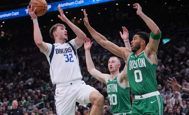 Dallas Mavericks forward Cooper Flagg (32) shoots over Boston Celtics' Jayson Tatum (0) and Sam Hauser (30) during the first half of an NBA basketball game, Friday, March 6, 2026, in Boston. (AP Photo/Charles Krupa)