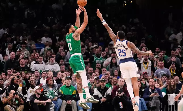 Boston Celtics forward Jayson Tatum (0) goes up to shoot over Dallas Mavericks forward P.J. Washington (25) during the first half of an NBA basketball game, Friday, March 6, 2026, in Boston. (AP Photo/Charles Krupa)