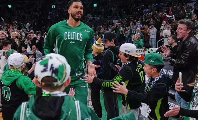 Boston Celtics forward Jayson Tatum, who has not played since injuring his achilles tendon during the 2025 NBA playoffs, is greeted by fans prior to an NBA basketball game against the Dallas Mavericks, Friday, March 6, 2026, in Boston. (AP Photo/Charles Krupa)