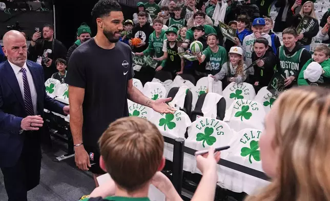 Boston Celtics forward Jayson Tatum, second from left, who has not played since injuring his achilles tendon during the 2025 NBA playoffs, is greeted by fans during a practice prior to an NBA basketball game against the Dallas Mavericks, Friday, March 6, 2026, in Boston. (AP Photo/Charles Krupa)