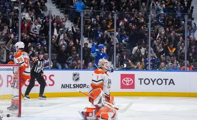 Vancouver Canucks' Drew O'Connor, back, celebrates his goal against Anaheim Ducks goalie Lukas Dostal during the third period of an NHL hockey game, in Vancouver, on Tuesday, March 24, 2026. (Darryl Dyck/The Canadian Press via AP)
