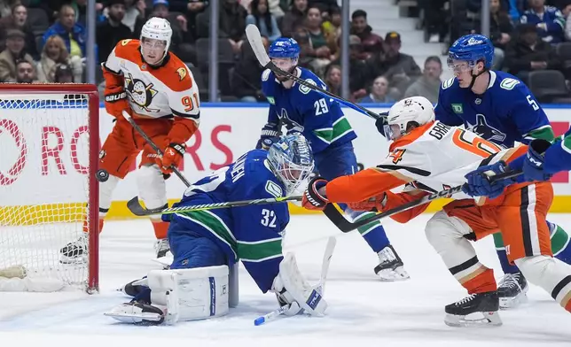 Anaheim Ducks' Mikael Granlund, front right, scores against Vancouver Canucks goalie Kevin Lankinen (32) as Tom Willander (5), Marcus Pettersson (29) and Anaheim's Leo Carlsson (91) watch during the second period of an NHL hockey game, in Vancouver, on Tuesday, March 24, 2026. (Darryl Dyck/The Canadian Press via AP)