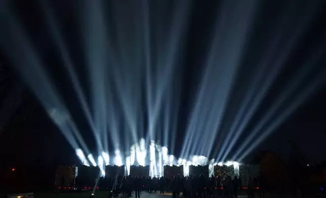 People attend a ceremony at a memorial for killed civilians to mark the fourth anniversary of the liberation of Bucha, Ukraine, on Monday, March 30, 2026. (AP Photo/Evgeniy Maloletka)
