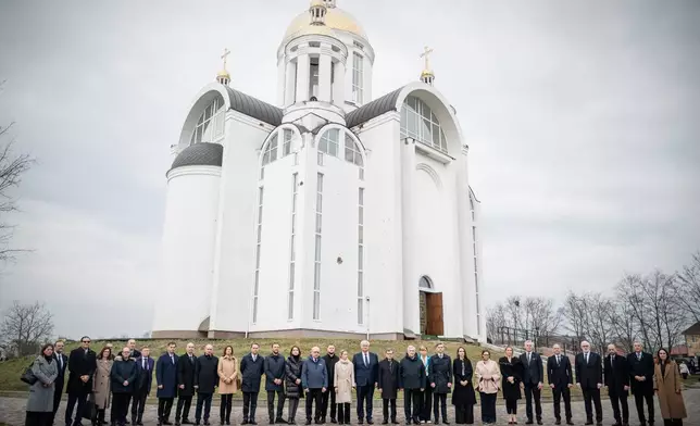 In this photo provided by the Ukrainian Foreign Ministry Press Office, High Representative of the European Union for Foreign Affairs and Security Policy Kaja Kallas, center left, Ukraine's Foreign Minister Andrii Sybiha, center right, and EU foreign ministers attend a commemorating ceremony in Bucha, Ukraine, Tuesday, March 31, 2026. (Ukrainian Foreign Ministry Press Office via AP)