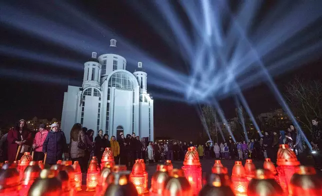 People attend a ceremony at a memorial for killed civilians to mark the fourth anniversary of the liberation of Bucha, Ukraine, on Monday, March 30, 2026. (AP Photo/Evgeniy Maloletka)