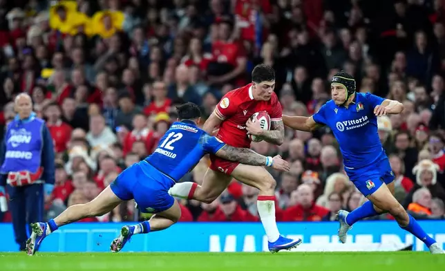 Wales' Louis Rees-Zammit is tackled by Italy's Tommaso Menoncello during the Men's Six Nations match between Wales and Italy in Cardiff, Wales, Saturday March 14, 2026. (David Davies/PA via AP)