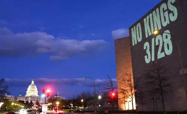 A message promoting an upcoming "No Kings" protest is projected on the National Gallery of Art, with the U.S. Capitol seen in the background, Monday, March 23, 2026, in Washington. (AP Photo/Julia Demaree Nikhinson)
