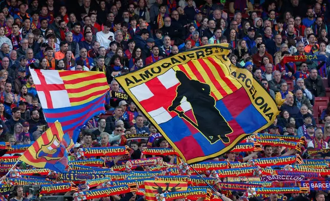 Fans of Barcelona's team cheer during the Spanish La Liga soccer match between Barcelona and Sevilla in Barcelona, Spain, Sunday, March 15, 2026. (AP Photo/Joan Monfort)