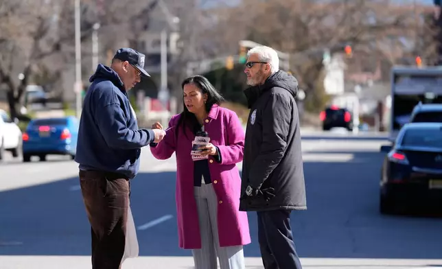 Analilia Mejia, the Democratic candidate running for New Jersey's 11th congressional district, talks to a passerby with Morristown Mayor Tim Dougherty on Tuesday, March 24, 2026, in Morristown, N.J. (AP Photo/Seth Wenig)