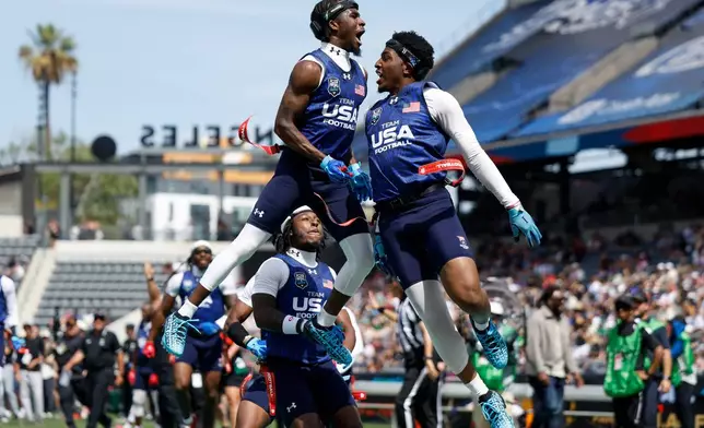 U.S. National Flag team's Isaiah Calhoun celebrates with teammate Shawn Theard Jr. the Fanatics Flag Football Classic against the Wildcats FFC, Saturday, March 21, 2026, in Los Angeles. (AP Photo/Caroline Brehman)