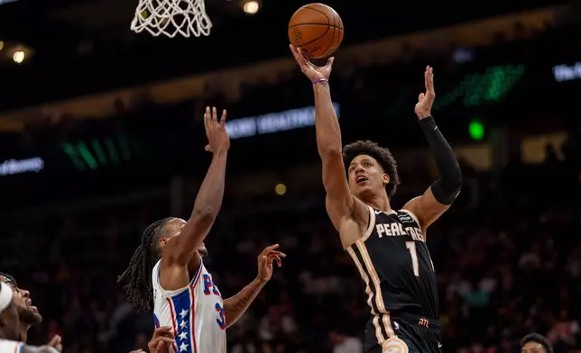 Atlanta Hawks forward Jalen Johnson (1) attempts a basket against Philadelphia 76ers forward Jabari Walker (33) during the first half of an NBA basketball game, Saturday, March 7, 2026, in Atlanta. (AP Photo/Erik Rank)