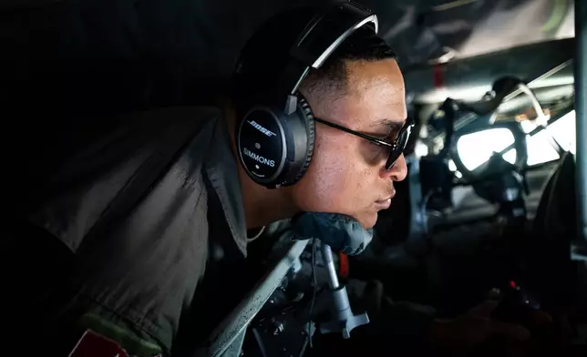 In this photo provided by the U.S. Air National Guard, U.S. Air Force Tech. Sgt. Tyler Simmons, an in-flight refueling specialist with the 121st Air Refueling Wing, refuels a C-17 Globemaster with a KC-135 Stratotanker during a teacher orientation flight at Rickenbacker Air National Guard Base, Ohio, on April 27, 2023. (Airman First Class Ivy Thomas/U.S. Air National Guard via AP)