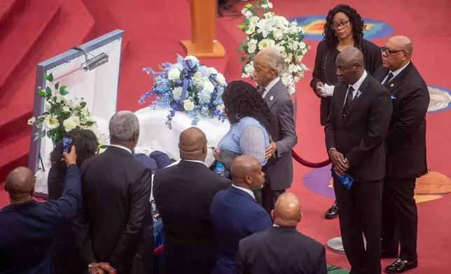 The Rev. Al Sharpton walks with Audrey Jones to pay respects to her brother Steven Jones, a man in a mental health crisis who was shot by police, during Jones' funeral service at The First Cathedral, Thursday, March 26, 2026 in Bloomfield, Conn. (Aaron Flaum/Hartford Courant via AP)