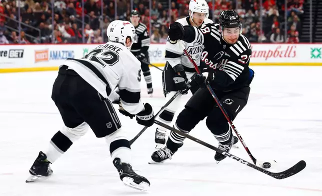 New Jersey Devils right wing Timo Meier (28) plays the puck against Los Angeles Kings defenseman Brandt Clarke (92) during the second period of an NHL hockey game, Saturday, March 14, 2026, in Newark, N.J. (AP Photo/Noah K. Murray)