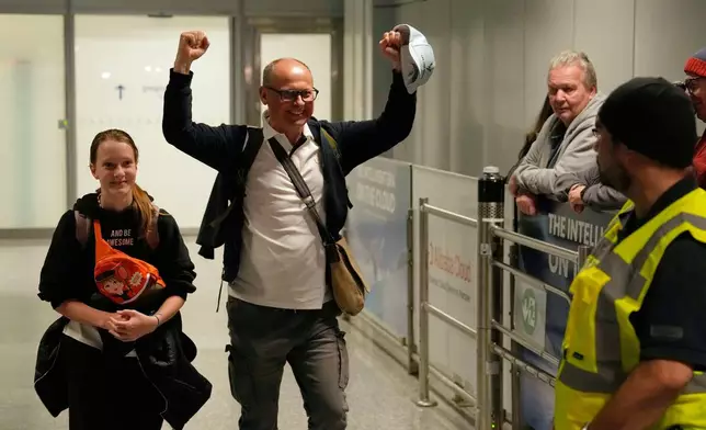 A man celebrates as he arrives at the International Airport in Frankfurt, Germany, after being evacuated from Dubai on a commercial flight, Tuesday, March 3, 2026. (AP Photo/Michael Probst)