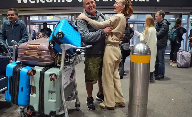 Jeff and Rebecca Moses from Manchester, arrive at Terminal 4 of London Heathrow Airport on a flight from Abu Dhabi in the United Arab Emirates, Monday, March 2, 2026. (Yui Mok/PA via AP)