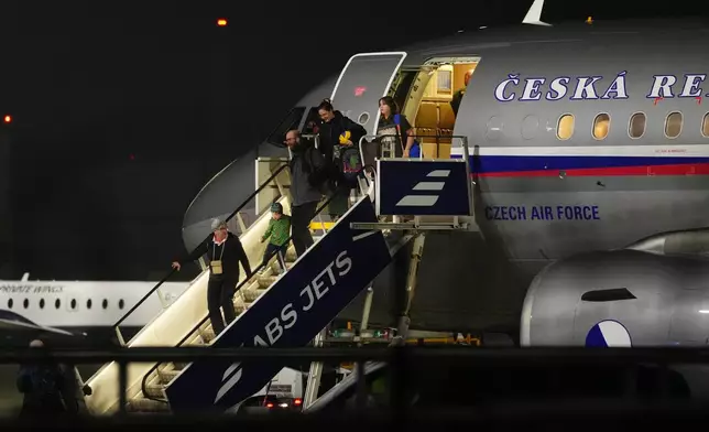 People arrive at the airport after being evacuated from the Middle East on a government flight, in Prague, Czech Republic, Tuesday, March 3, 2026. (AP Photo/Petr David Josek)