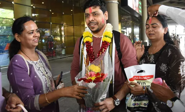 An Indian man who was stranded in Dubai is welcomed by his relatives upon his arrival at Chhatrapati Shivaji Maharaj International Airport in Mumbai, India, Tuesday, March 3, 2026. (AP Photo)