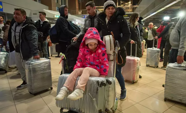 Antonia, 5 years old, sits on suitcases upon arriving at the Henri Coanda International airport after being evacuated from Israel via Egypt on a commercial flight in Otopeni, Romania, Tuesday, March 3, 2026. (AP Photo/Vadim Ghirda)