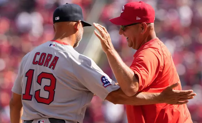 Boston Red Sox manager Alex Cora, left, Cincinnati Reds manager Terry Francona, right greet each other before an opening-day baseball game in Cincinnati, Thursday, March 26, 2026. (AP Photo/Carolyn Kaster)