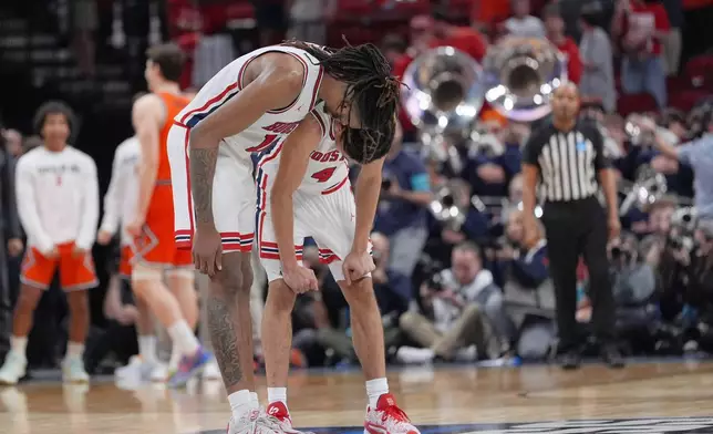 Houston forward Joseph Tugler (11) and guard Kingston Flemings (4) react after losing to Illinois in the Sweet 16 of the NCAA college basketball tournament Friday, March 27, 2026, in Houston. (AP Photo/Eric Gay)