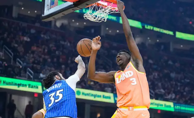 Cleveland Cavaliers center Thomas Bryant (3) dunks over Orlando Magic center Goga Bitadze (35) in the first half of an NBA basketball game in Cleveland, Tuesday, March 24, 2026. (AP Photo/Sue Ogrocki)