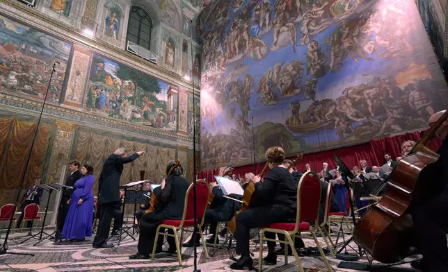 Tenor Matthew McKinney, left, and soprano Elizabeth Watts, second from left, sing Angels Unawares byJames MacMillan, conducted by Harry Christopher, third from left, in the Sistine Chapel at the Vatican, Sunday, March 22, 2026. (AP Photo/Domenico Stinellis)